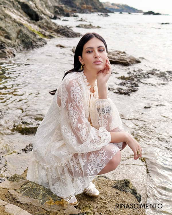 Frau im Kleid aus Spitze auf einem Fels